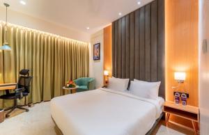 a hotel room with a white bed and a desk at Scarlet in Indore