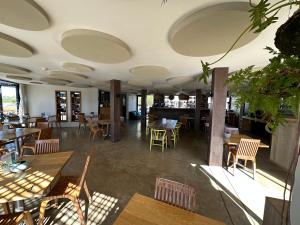 ein Restaurant mit Holztischen und -stühlen und einer Cafeteria in der Unterkunft Windtown Lagoon Hotel in Langebaan