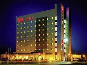 a hotel building with a lot of windows at night at Ibis Juarez Consulado in Ciudad Juárez