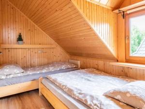 a bedroom with two beds in a wooden cabin at Domki u Teresy in Dębno