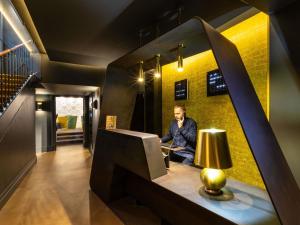 a man sitting at a desk in a room at Ibis Styles Strasbourg Centre Gare in Strasbourg