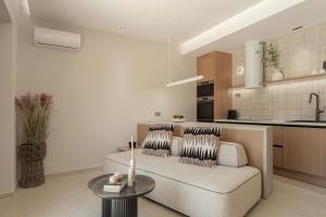 a living room with a couch and a kitchen at Increteblue Suites in Plakias