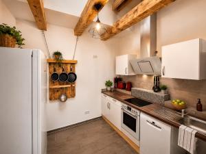 a kitchen with white cabinets and a refrigerator at Spreewald Błota Jéwa Ferienwohnung mit Terrasse und Parkplatz in Lübbenau