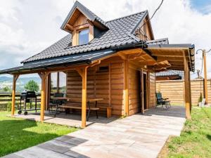 a wooden cabin with a table and a roof at Domki u Teresy in Dębno