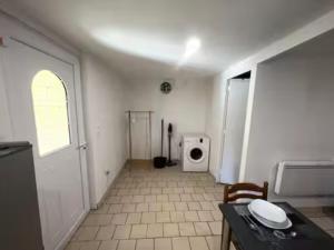 a room with a kitchen with a table and a microwave at Studio avec terrasse in Château-lʼÉvêque