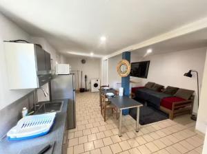 a kitchen and a living room with a couch at Studio avec terrasse in Château-lʼÉvêque