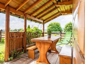 a wooden deck with a table and a green chair at Domki u Teresy in Dębno