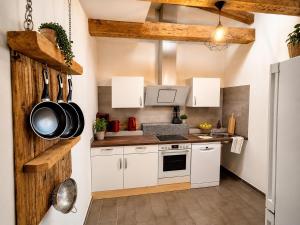 a kitchen with white cabinets and a wooden wall at Spreewald Błota Jéwa Ferienwohnung mit Terrasse und Parkplatz in Lübbenau
