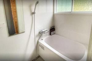 a bathroom with a shower and a white tub at イーリス軽井沢 in Naganohara