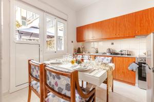 a kitchen with a white table and chairs in a room at Enora Loutraki Guesthouse in Loutraki +53 photos