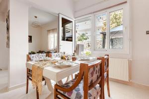a dining room with a white table and chairs at Enora Loutraki Guesthouse in Loutraki