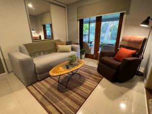 a living room with a couch and a table at The Sanctuary on William - Nature Reserve Hideaway in Ormiston