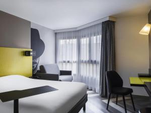 a hotel room with a bed and a desk and chairs at ibis Styles Nice Vieux Port in Nice