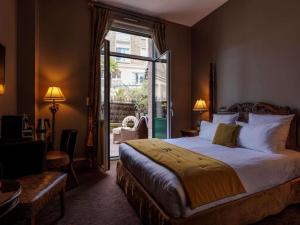 a hotel room with a bed and a door to a patio at Royal Emeraude Hotel Dinard - MGallery Collection in Dinard +163 photos