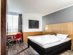 a hotel room with a bed and a desk at ibis Hotel Eisenach in Eisenach