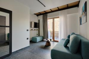 a living room with a blue couch and a window at Agia Triada Suites in Heraklio