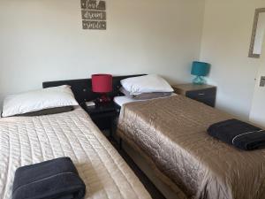 a bedroom with two beds and a red lamp on a table at A Home from Home -2 Bed Flat & Free Driveway Parking in Ascot