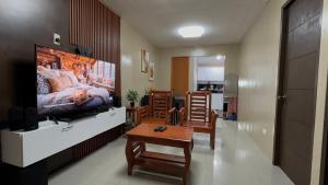 a living room with a television and a living room with a couch at Welcome Home, whole 2 bedroom unit - VCDU Riverview, Mabini Plains in Mabini