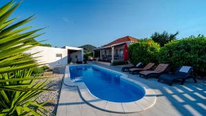a swimming pool with two chairs and a house at MAB Sweet Home By Villas Guide in Vela Luka