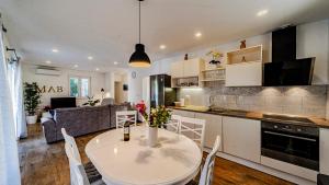 a kitchen and living room with a white table and chairs at MAB Sweet Home By Villas Guide in Vela Luka
