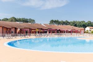 a large swimming pool in front of a resort at Villa du Lac - Conciergerieland in Soustons