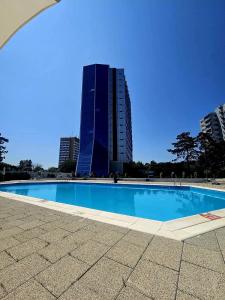 a swimming pool in front of a tall building at Sea View Ani in Olimp