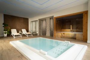 a large tub in a room with a table and chairs at Helios Benidorm in Benidorm