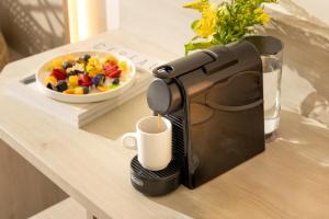 a coffee machine on a table with a bowl of fruit at Helios Benidorm in Benidorm