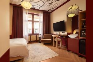 a hotel room with a bed and a desk with a television at TWENTYSEVEN Boutique in Budapest