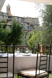a table with wine glasses on a balcony at Auberge De La Madone in Peillon