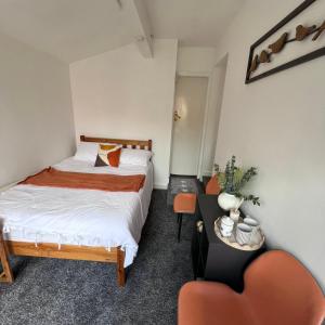 a small bedroom with a bed and a chair at Rizvi house in Moston