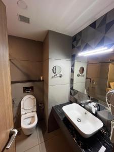 a bathroom with a sink and a toilet at MANDARIN SKY in Kannur