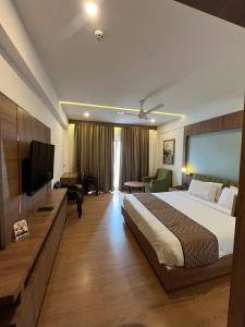 a hotel room with a bed and a television at MANDARIN SKY in Kannur