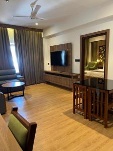 a living room with a couch and a bed and a television at MANDARIN SKY in Kannur