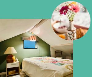 a bedroom with a bed and a vase with flowers at Cocon à la ferme - Lac du Der in Loisy-sur-Marne