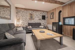 a living room with a couch and a table at Gite - La grange Tima in Orgeix