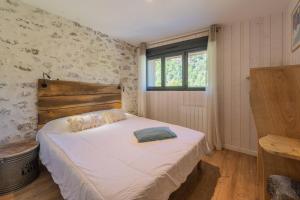 a bedroom with a bed and a window in it at Gite - La grange Tima in Orgeix