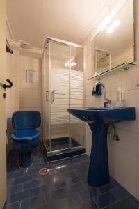 a bathroom with a blue toilet and a sink at Greco Hotel in Hydra +63 photos