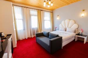 a bedroom with a large bed and a chair at Mai İnci Pera Hotel İstanbul in Istanbul