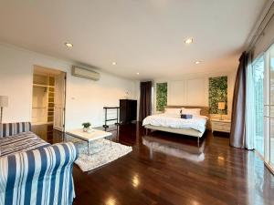 a bedroom with a bed and a living room at Pool Villa Ramkhamhaeng 9 in Bangkok +35 photos