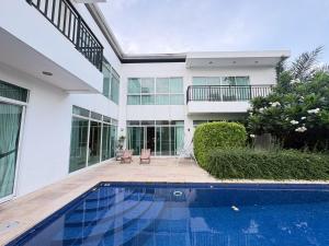a house with a swimming pool in front of it at Pool Villa Ramkhamhaeng 9 in Bangkok