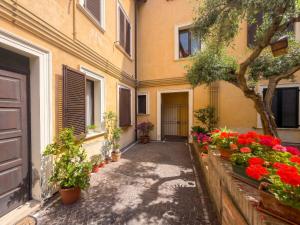 an alley with flowers in pots in front of a building at Piccola Corte in Fano +3 photos