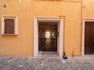 an orange building with a door with a gate at Piccola Corte in Fano