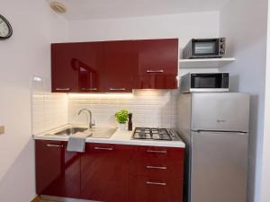 a kitchen with red cabinets and a white refrigerator at Piccola Corte in Fano