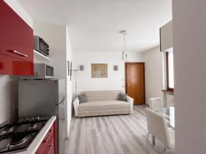 a kitchen and living room with a couch in a room at Piccola Corte in Fano