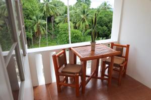a table and chairs in a room with a window at Guindulman Bay Tourist Inn in Guindulman