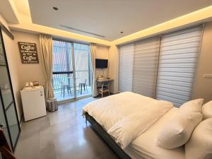 a bedroom with a large bed and a balcony at 會呼吸的房-採自助式入住-有電梯 in Huwei