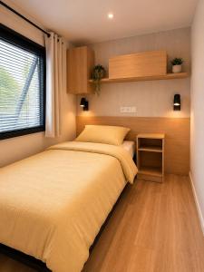 a bedroom with a bed and a window at Escapade in Lège-Cap-Ferret