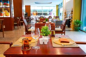 a wooden table with wine glasses and napkins on it at Elite Suites Patong in Patong Beach
