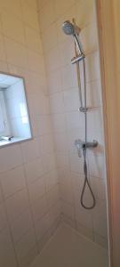 a shower with a shower head in a bathroom at Le Nid De Demolombe in Caen